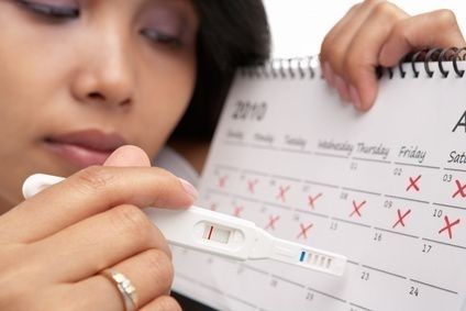 žena u kalendáře s těhotenstkým testem