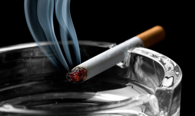 kouřící cigareta odložená na popelníku