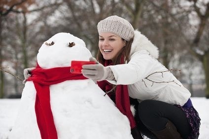 Dívka se fotí se sněhulákem