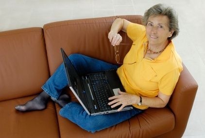 žena sedící na gauči s notebookem
