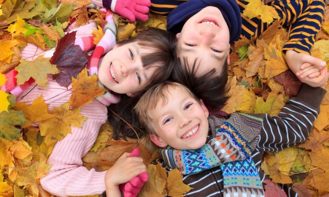 děti leží ve spadaném listí