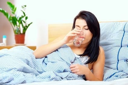 žena pije vodu v posteli