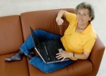 žena sedící na gauči s notebookem