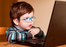 dítě s brýlemi před laptopem