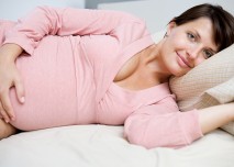 těhotná žena leží v posteli